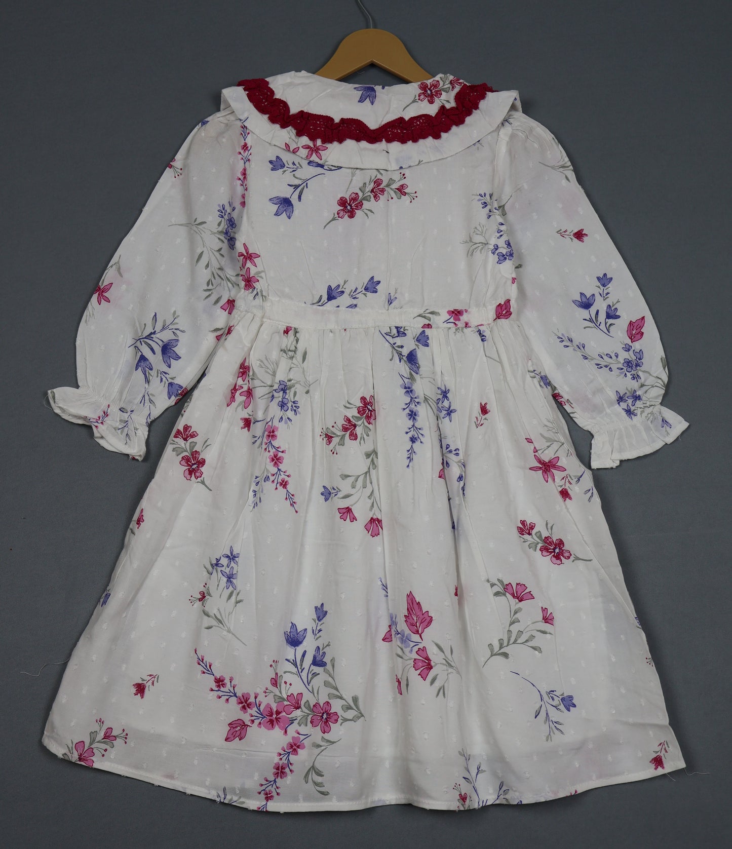 Floral dress on a hanger against a gray background