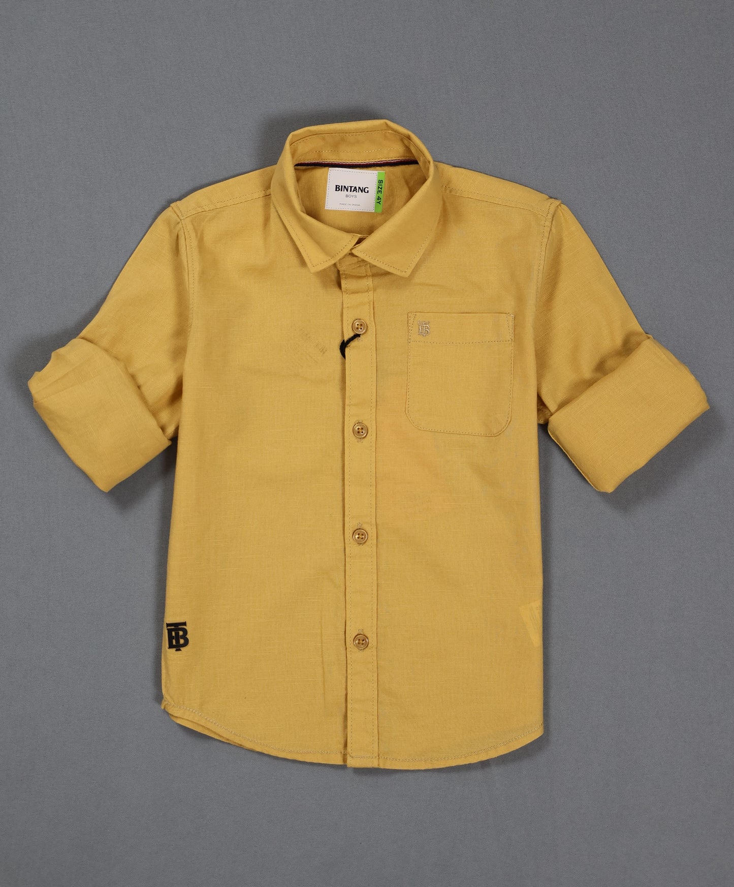 Yellow shirt with rolled-up sleeves on a gray background