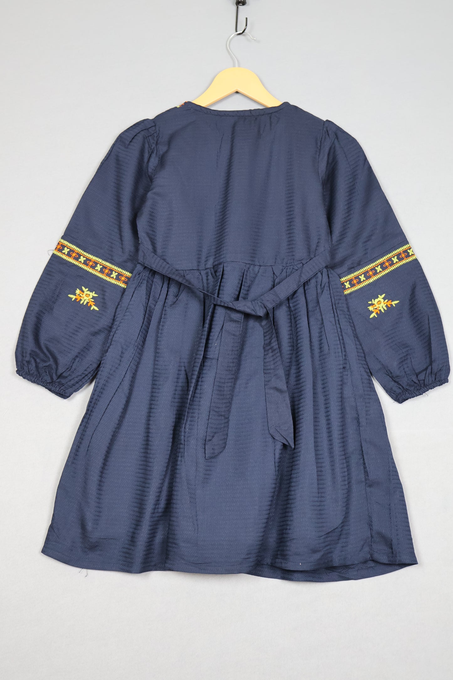 Blue garment with yellow embroidery on a white background