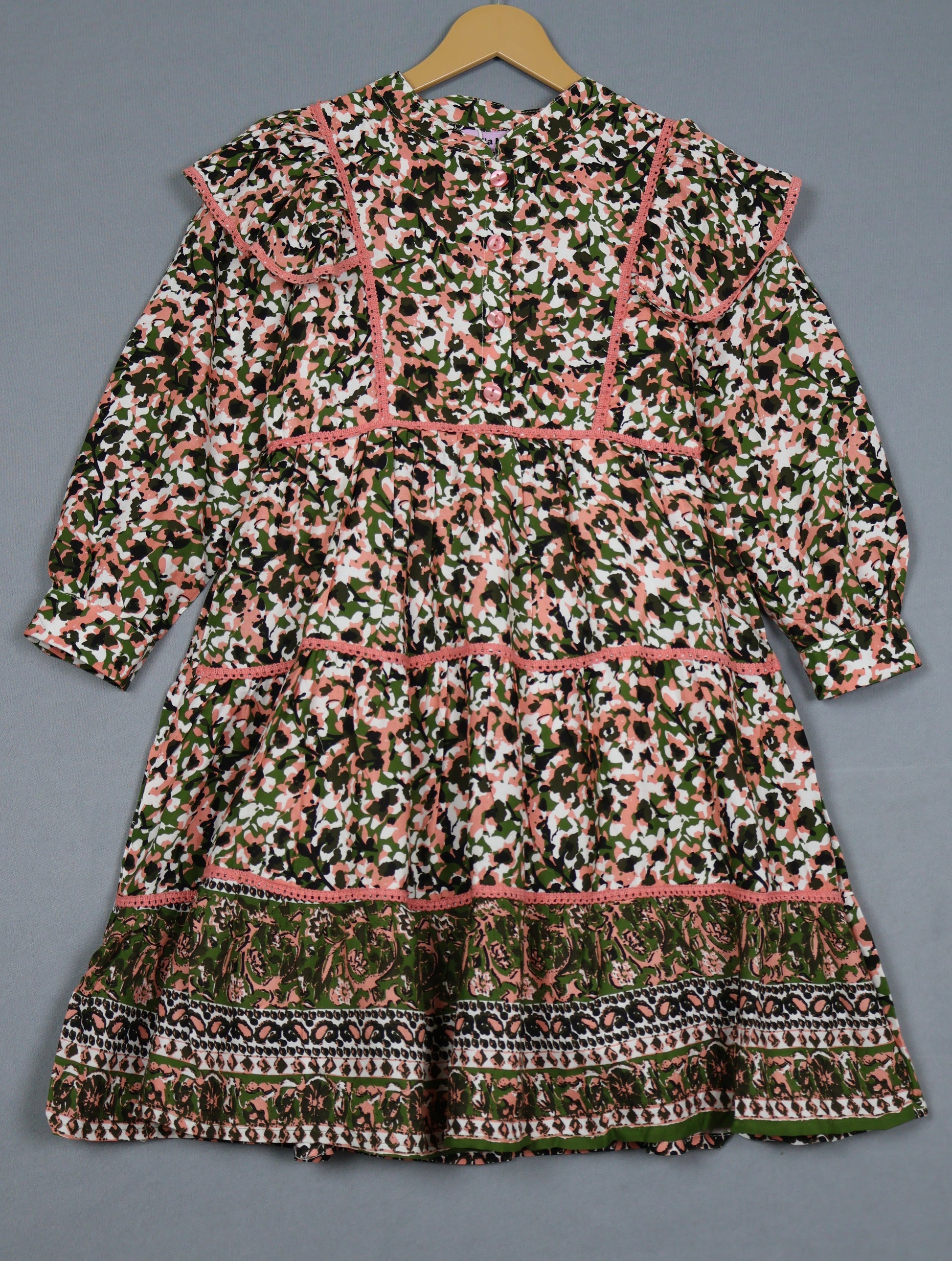 Patterned dress on a hanger against a gray background