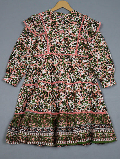 Patterned dress on a hanger against a gray background