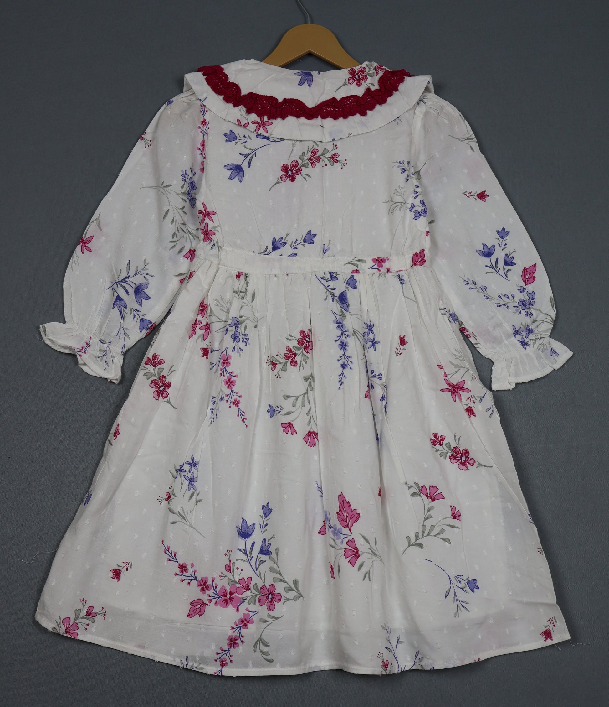 Floral dress on a hanger against a gray background