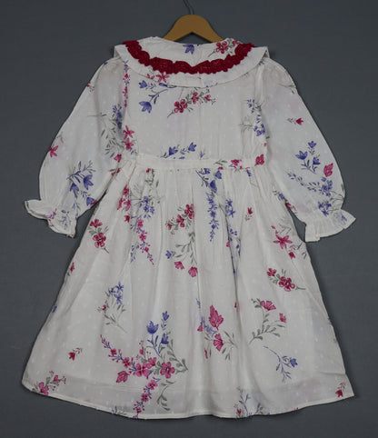 Floral dress on a hanger against a gray background