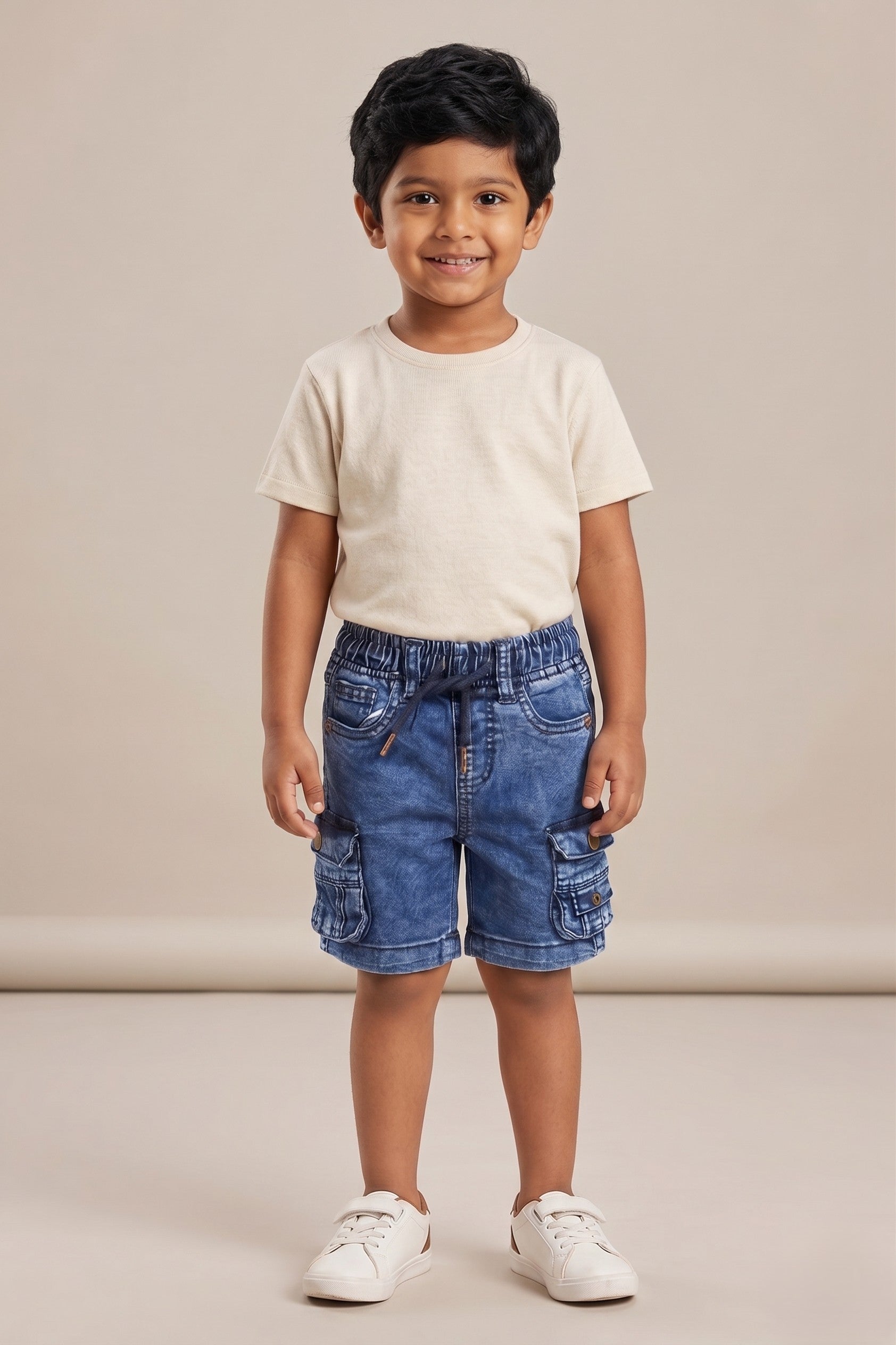 A kid wearing FYST brand lightweight acid-wash denim cargo shorts featuring an elastic drawstring waistband and functional side flap pockets with button details.