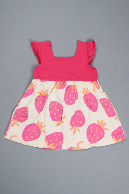 Children's dress with pink top and strawberry patterned skirt on a gray background