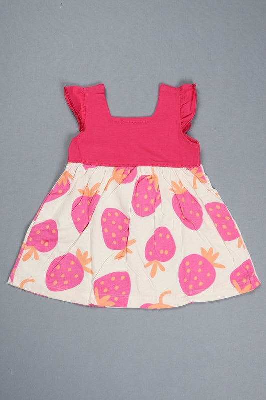 Children's dress with pink top and strawberry patterned skirt on a gray background