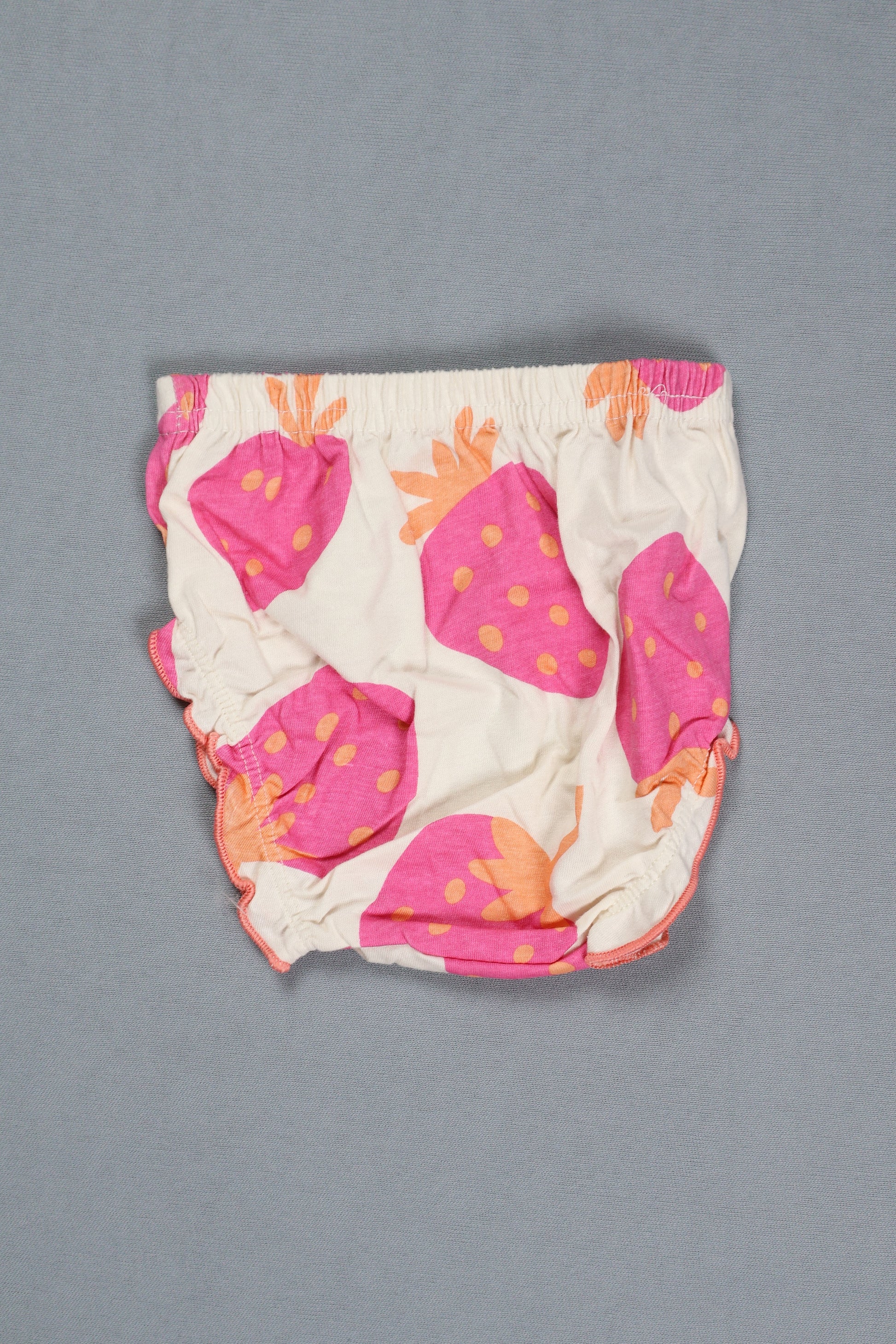 Baby diaper with pink and orange pineapple pattern on a gray background