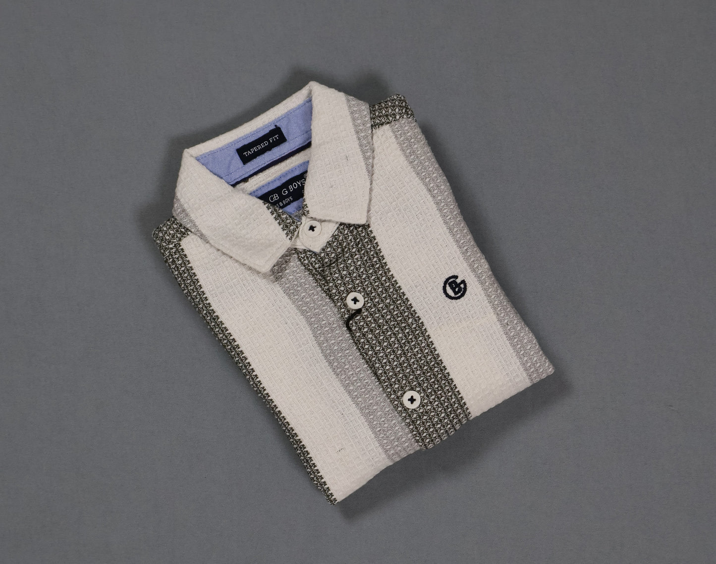 Folded shirt with patterned and solid collar on a gray background