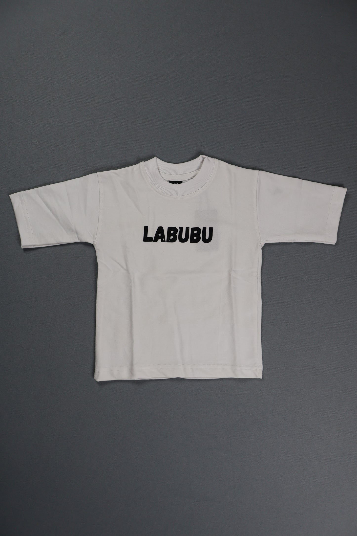 White sleeveless top with 'LABUBU' branding on a gray background