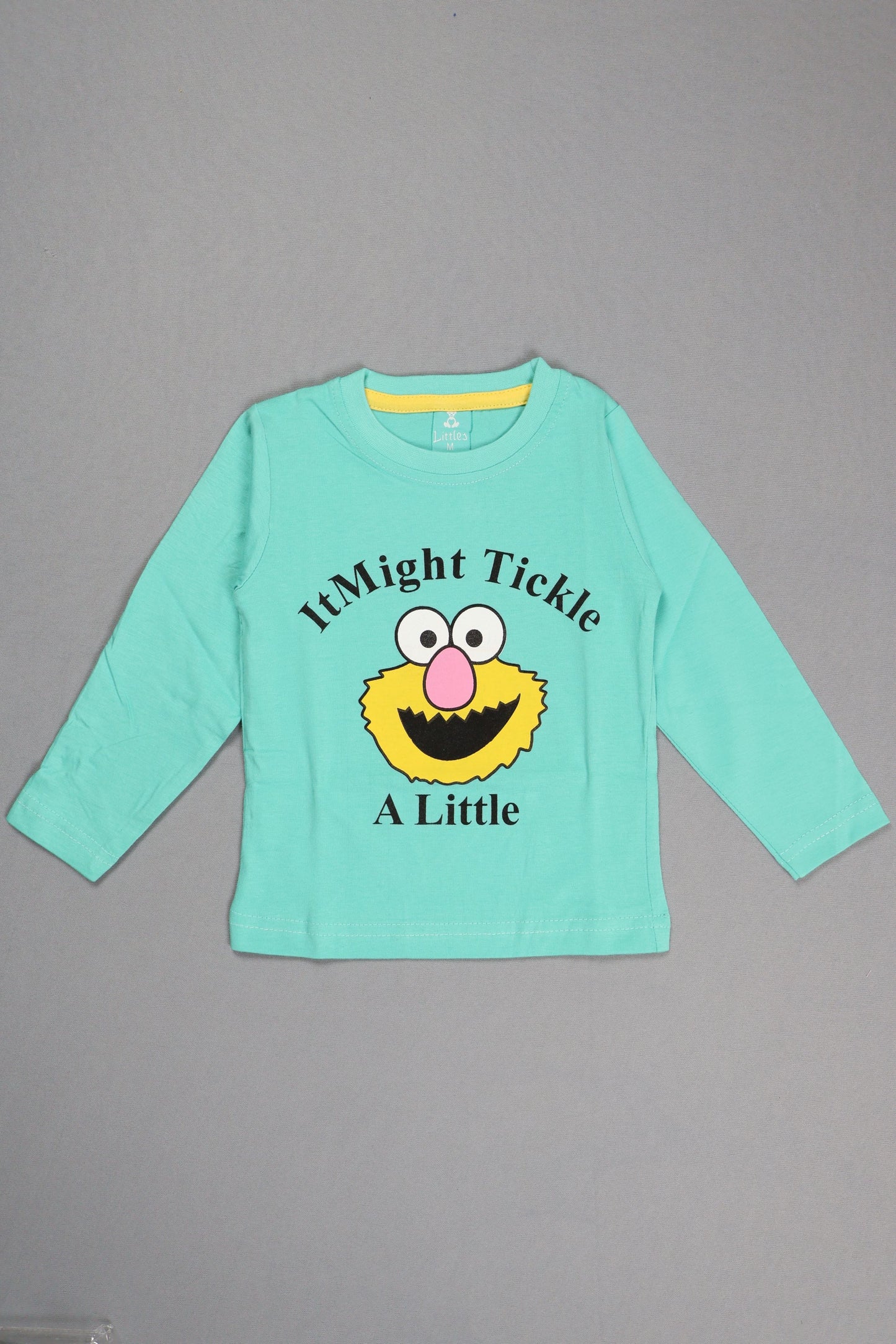Light blue long-sleeve shirt with a cartoon character and text on a gray background