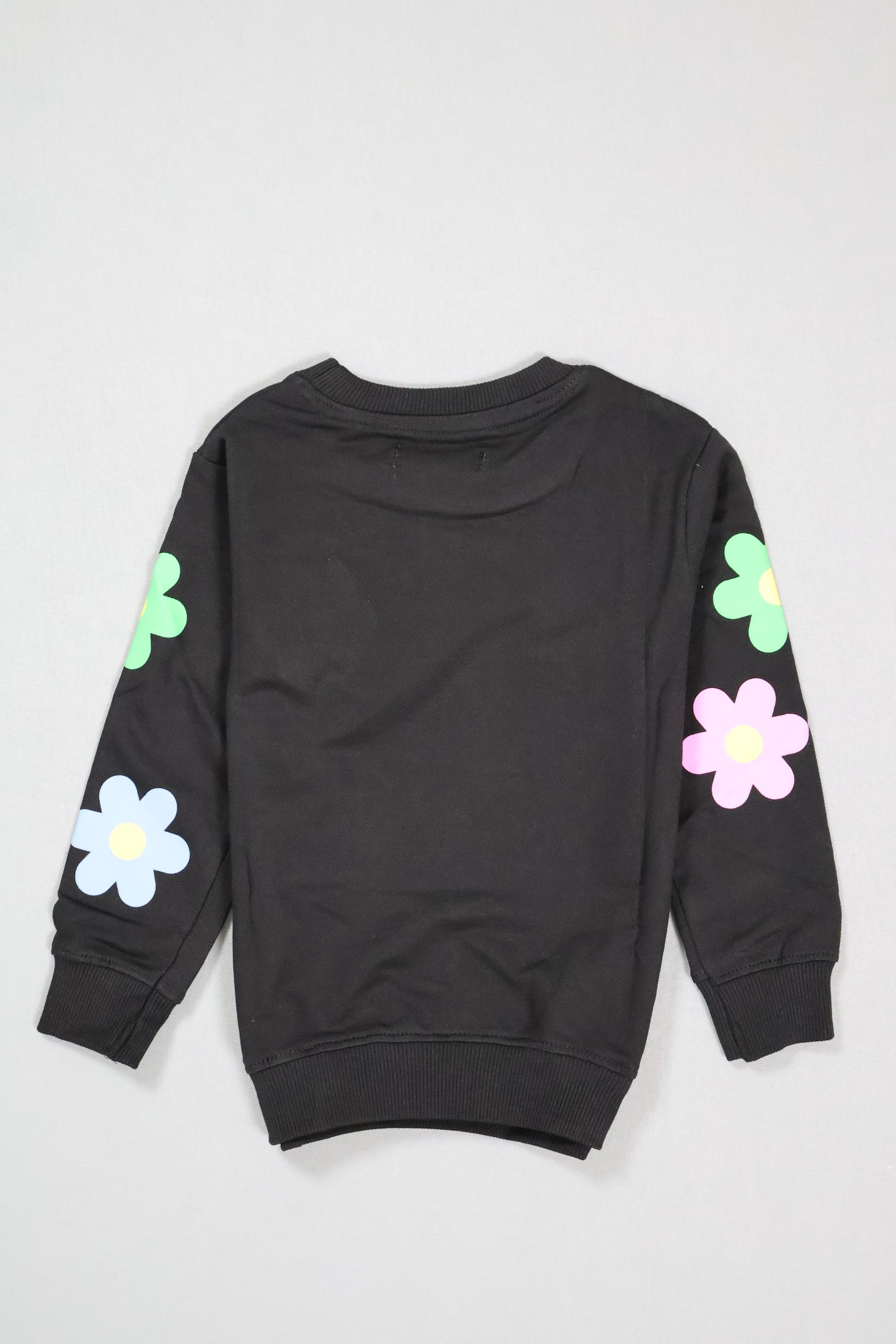 Black outfit with colorful flower designs on a light gray background