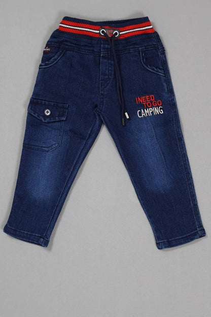 Blue jeans with a red and white striped waistband on a gray background
