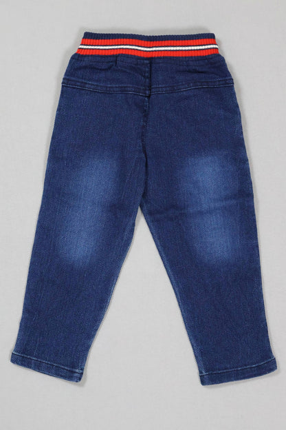 Blue jeans with a striped waistband on a gray background