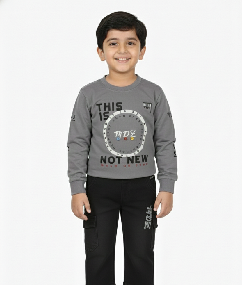 Child wearing a gray long-sleeve shirt with text and black pants on a white background