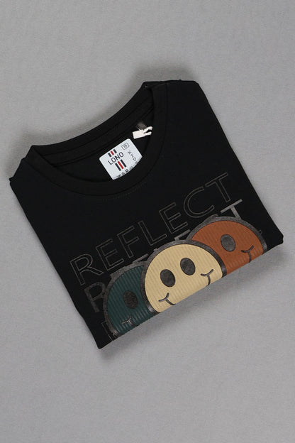 Black t-shirt with colorful smiley face designs and 'REFLECT' text on a gray background