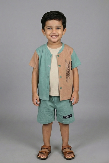 A young boy modeling a stylish three-piece summer set. The outfit features a sage green and sand brown color-block button-down shirt worn over a cream inner t-shirt, paired with matching sage green shorts. He is standing against a neutral grey background wearing brown sandals.