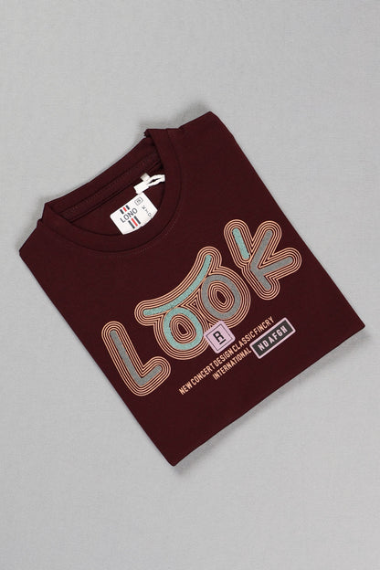Folded maroon t-shirt with text on a gray background