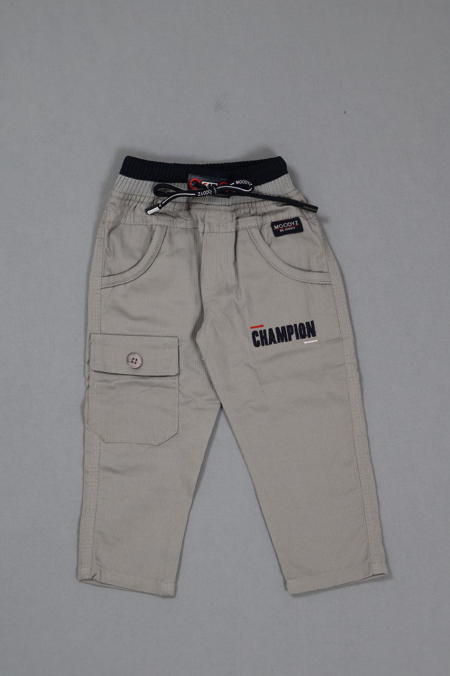 Beige pants with Champion branding on a gray background