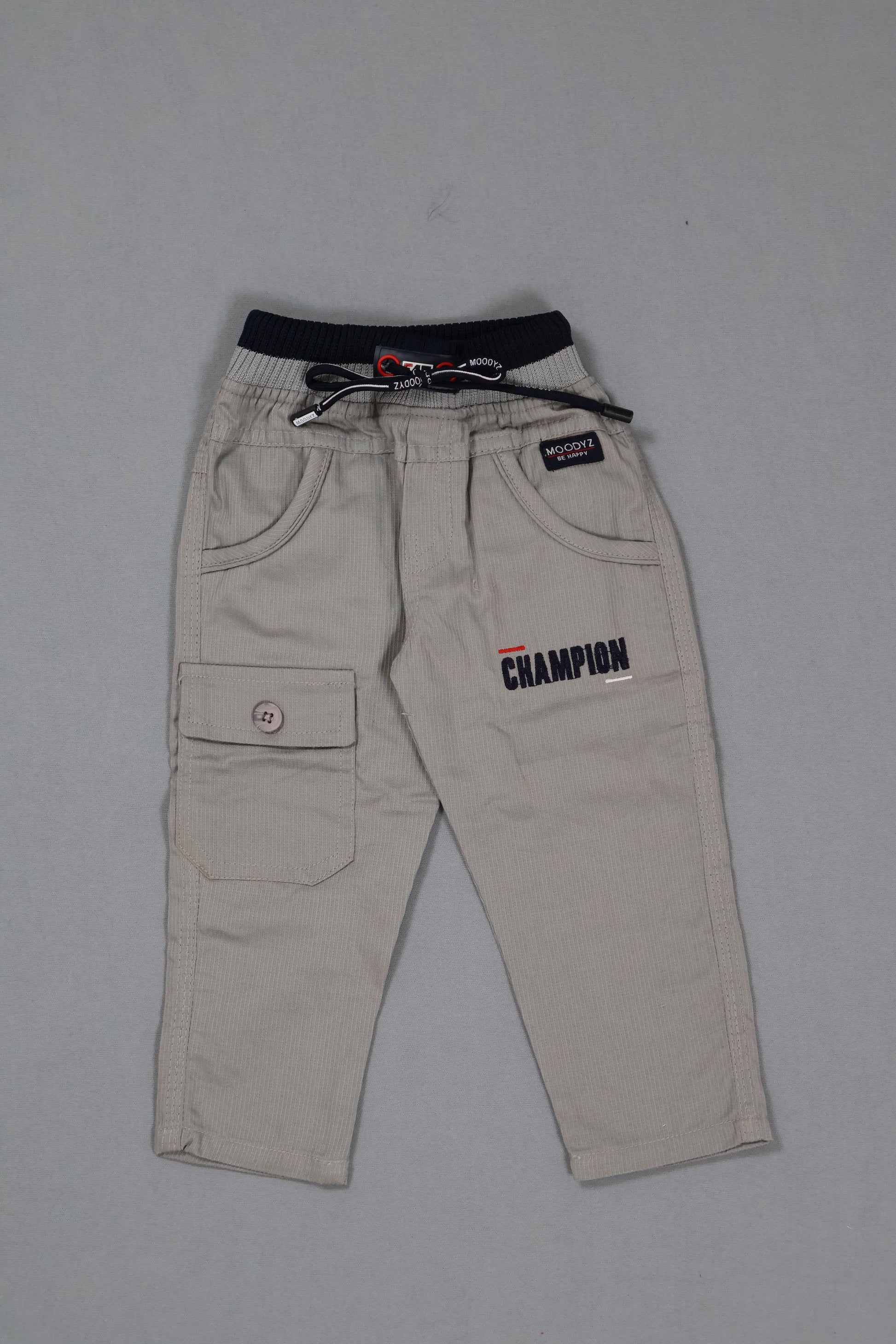 Beige pants with Champion branding on a gray background