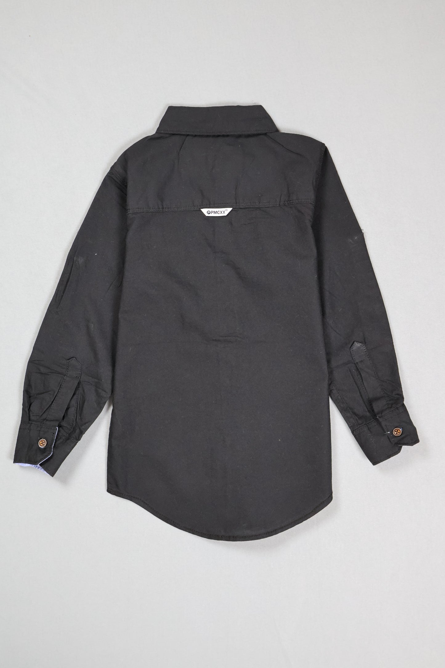 Folded black shirt on a light gray background