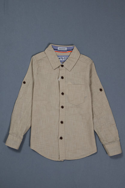 Fyst Boys' Beige Textured Long-Sleeve Button-Down Shirt with Single Chest Pocket and Roll-Up Sleeve Tabs, flat lay view on grey background.