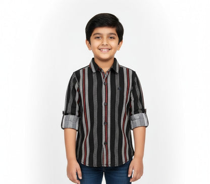 A young boy smiling in a studio portrait, modeling a Fyst brand black button-down shirt with intricate vertical patterns of grey stripes and red lines.