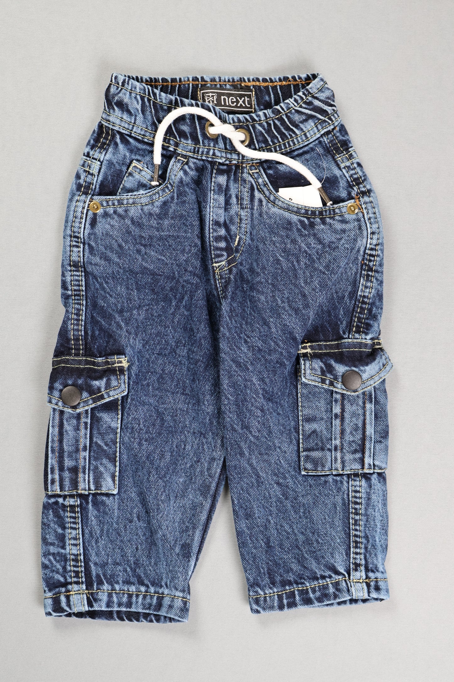 Folded blue jeans on a gray surface