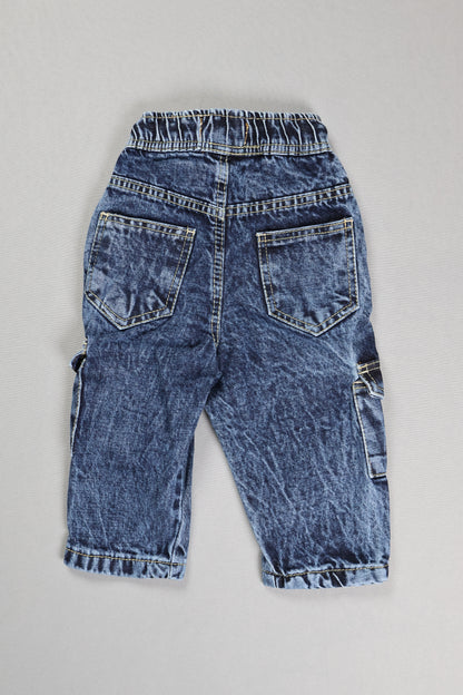 Pair of blue jeans laid flat on a gray surface