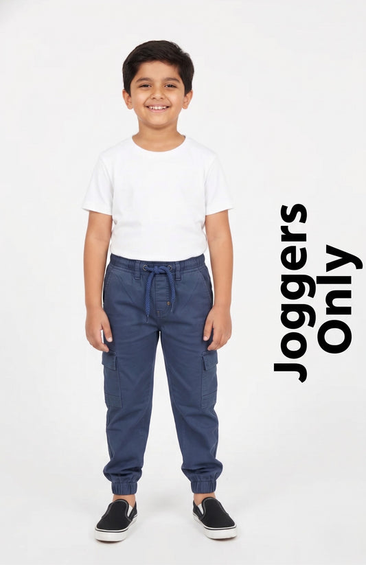 "A kid modeling Fyst navy blue cargo joggers featuring utility side pockets, an elastic drawstring waistband, and cinched ankle cuffs."