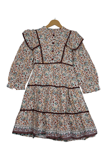 Floral dress on a hanger against a white background