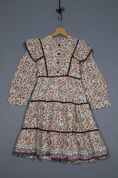 Floral-patterned garment on a hanger against a gray background