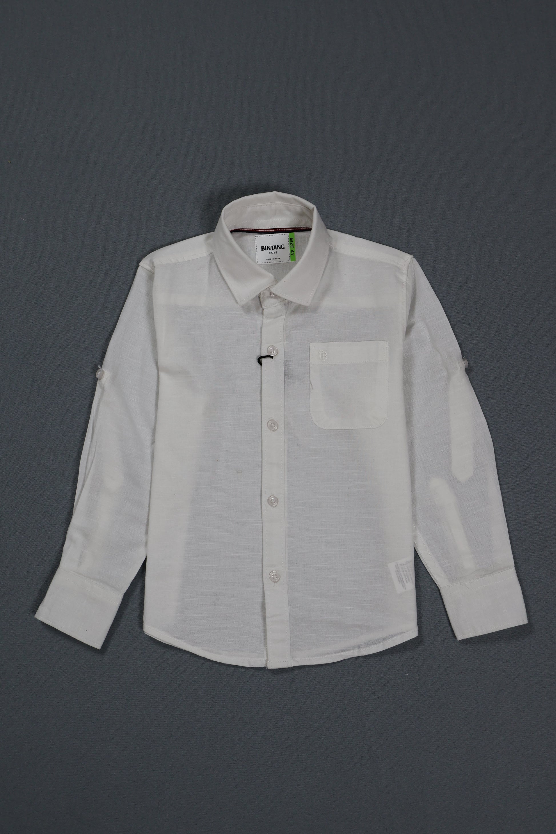 "A comprehensive product view of the Fyst boys' off-white casual button-down shirt. The main image showcases the premium cotton twill texture with a clean, front-facing profile featuring a single chest pocket and matching tonal buttons. Side-by-side thumbnails highlight the functional versatility of the garment, demonstrating both the full-length sleeves and the buttoned roll-up tab feature that allows for a relaxed, mid-arm style. The shirt is finished with a classic spread collar and a subtle curved hemli