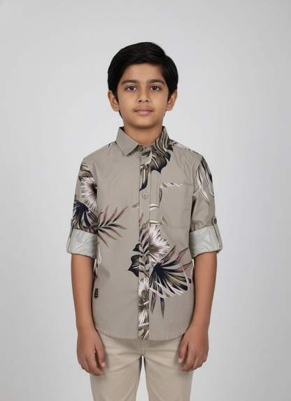 Boy wearing stone grey smart casual shirt with tropical leaf print and rolled sleeves