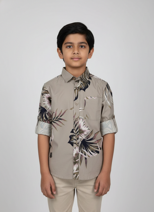 Boy wearing stone grey smart casual shirt with tropical leaf print and rolled sleeves