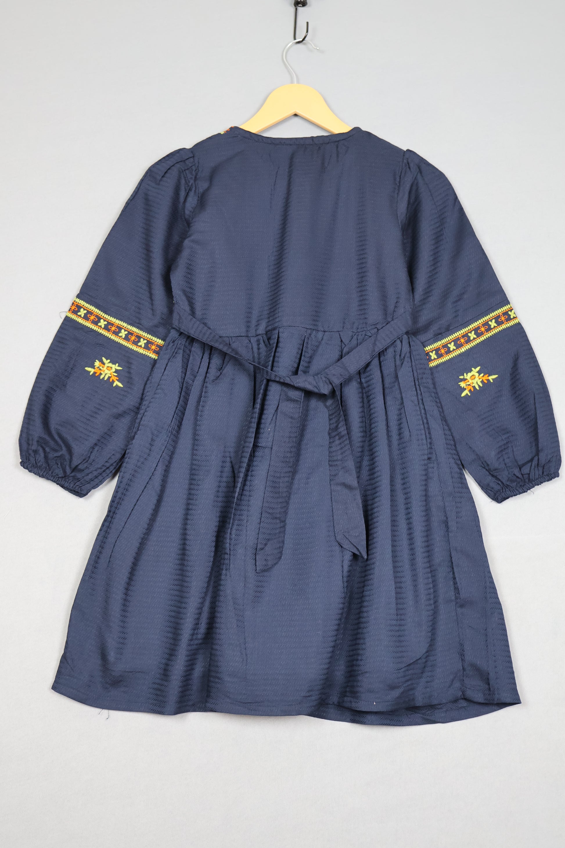 Blue garment with yellow embroidery on a white background