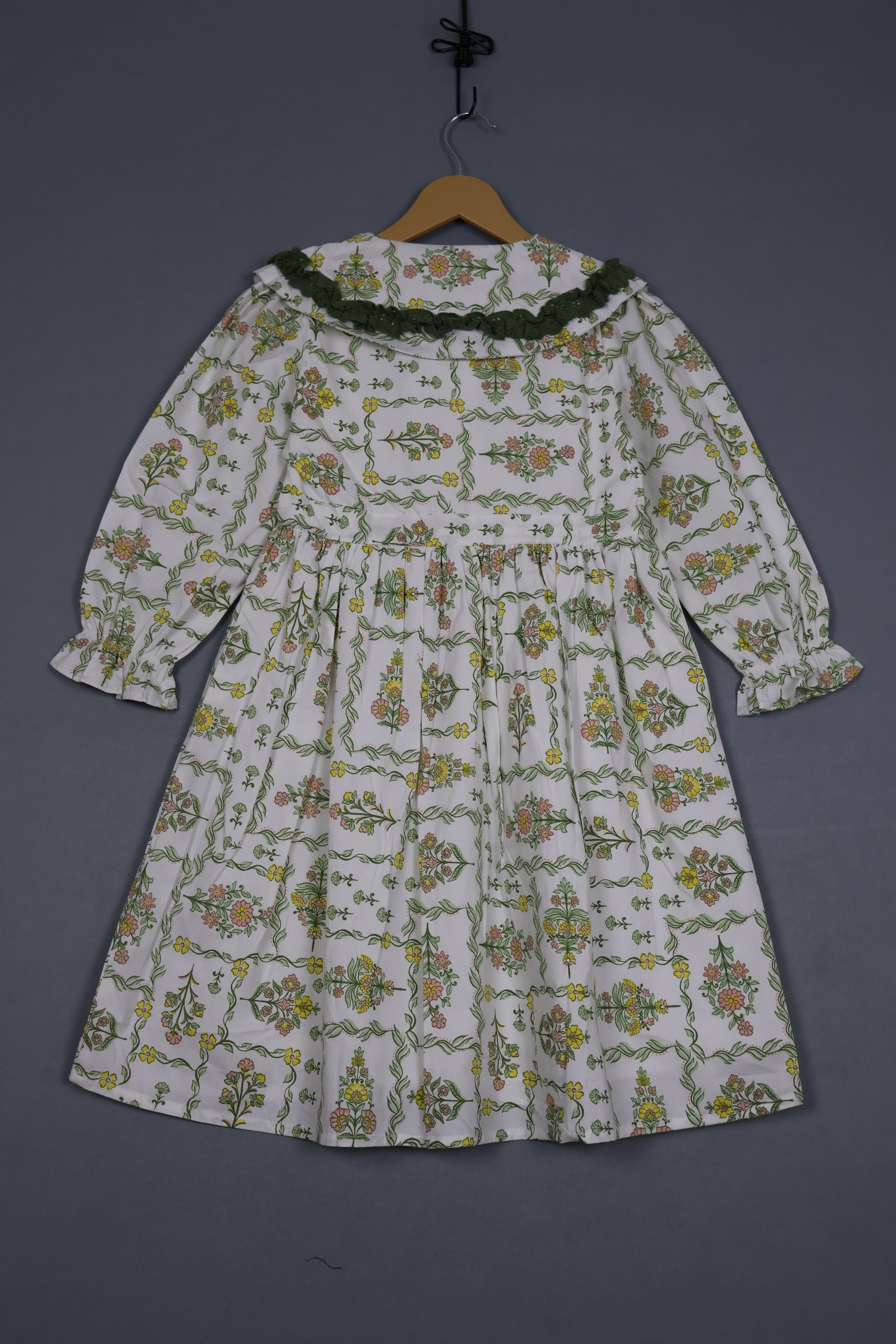 Floral patterned shirt on a hanger against a dark background
