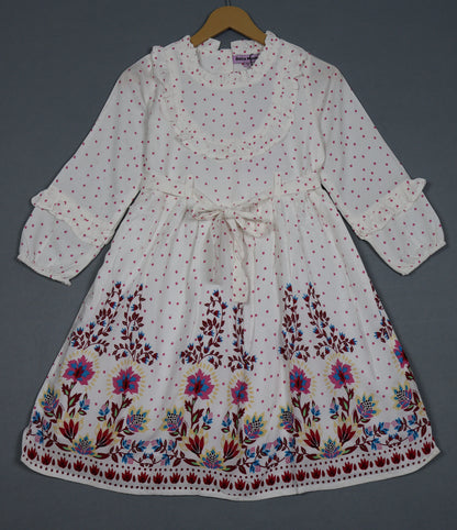 White dress with floral embroidery on a hanger against a gray background
